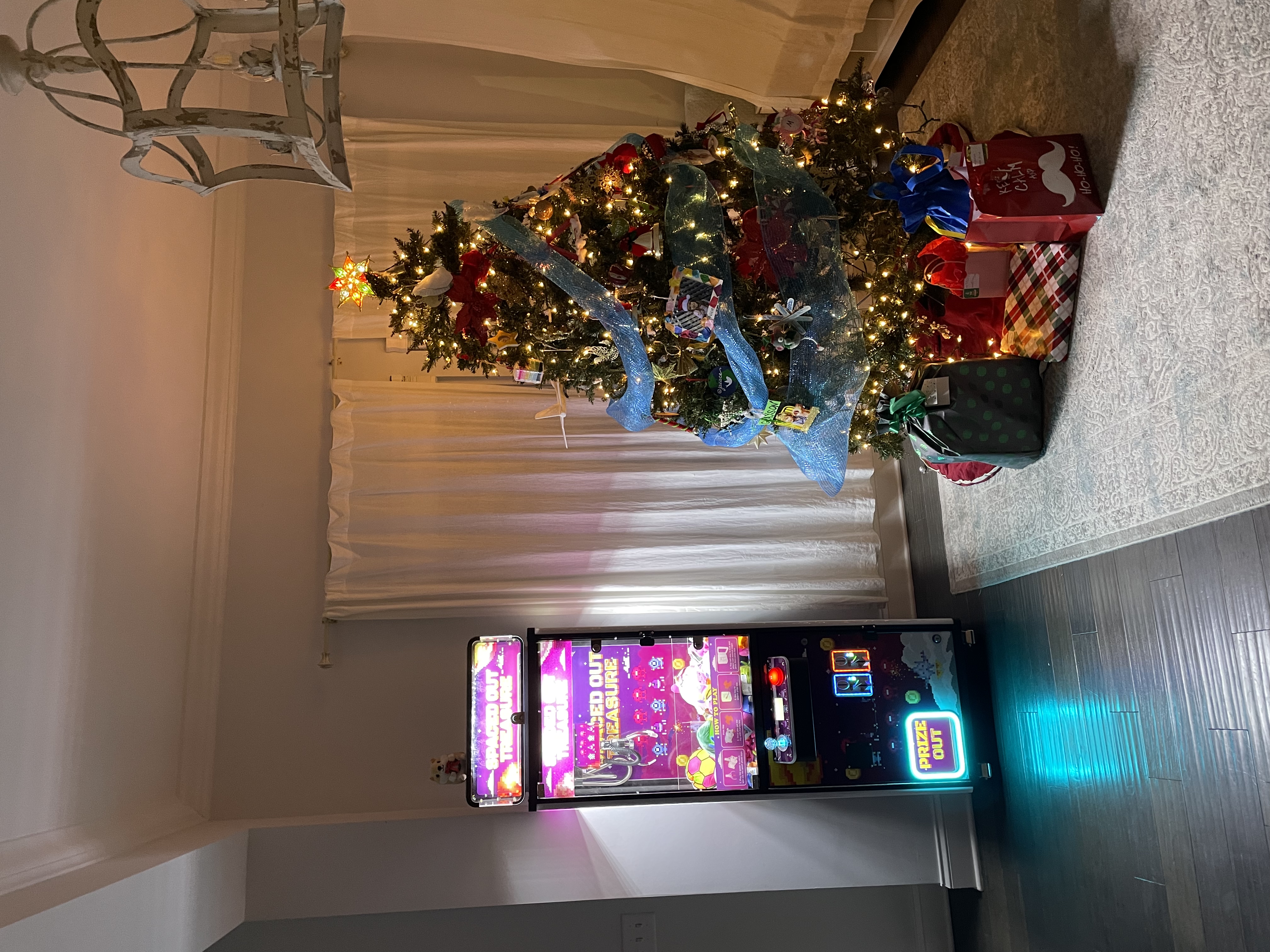 Claw machine next to a decorated Christmas tree
